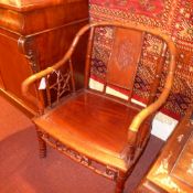 A pair of Chinese rosewood bamboo style armchairs with solid seats and star form decoration on the