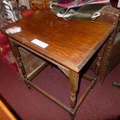 An early C20th oak table raised on turned stretchered suypports
