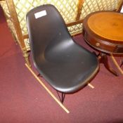 A contemporary designer Eiffel style rocking chair in black plastic on wooden supports