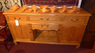 A Victorian pine dresser base fitted four drawers and pair of panelled doors with brass handles