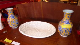 An Italian oval white glazed platter of basket design together with a pair of vases with flowers
