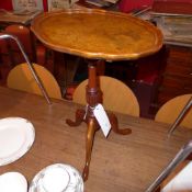 A burr walnut wine table with pie crust edge raised on column and tripod supports