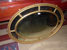 A gilt oval sectional wall hanging mirro