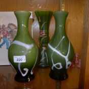 A pair of green glass vases and a simila