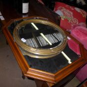 A gilded circular wall mirror with bevelled plate and a mahogany mirror