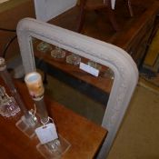 A distressed wall hanging mirror within