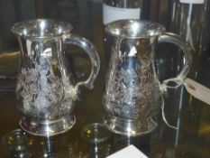 A pair of silver plated embossed tankard