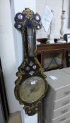 A Victorian papier mache barometer with mother of pearl and gilded detail