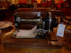 A vintage Frisster and Rossman sewing machine in oak case