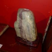 A large quartz crystal on a carved hardwood stand
