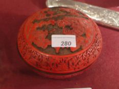 A Chinese Cinnabar lacquered carved lidded box with landscape reserves in relief