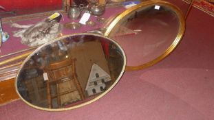 An oval gilt framed mirror and a similar (2)