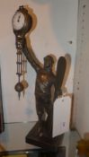 A bronze clock in the form of a pilot holding the swinging movement