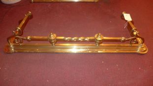 A Victorian brass fender with scrolling decoration