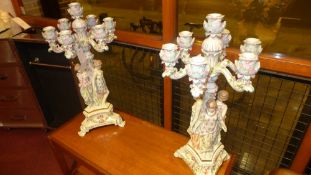 A pair of Meissen style porcelain seven branch candelabra each decorated with three maiden figural