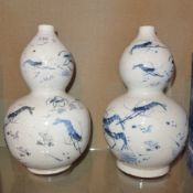 A pair of Chinese double gourd vases glazed white and decorated with prawns