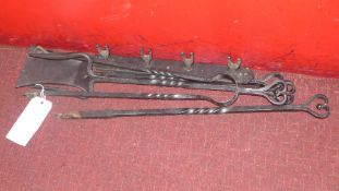 A wall mounting set of cast iron fire utensils including shovel and tongs