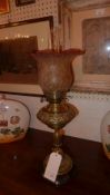 A Victorian brass oil lamp with embossed detail and frosted glass shade