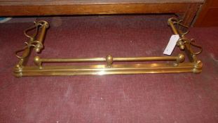 A Victorian brass fender with scrolling decoration