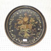 A C19th embroided silkwork panel of flowers in an oval ebonised frame