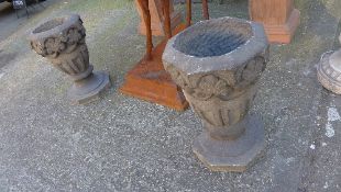 A pair of stone carved garden pots on pedestals
