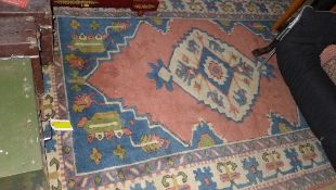 A hand knotted Caucasian rug the pink ground with stylized decoration