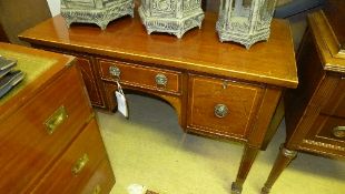A Regency mahogany and boxwood string inlaid kneehole desk on tapered supports