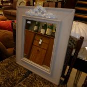 A distressed wall hanging mirror with carved crest