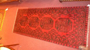 An Afghan runner the dark red field with