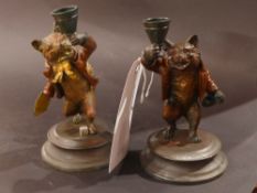A pair of cold painted candlesticks in t