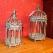 A pair of wrought iron and glazed storm