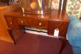 A mahogany kneehole writing table fitted