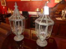 A pair of wrought iron and glazed storm