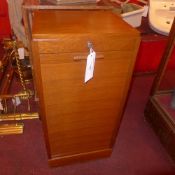 An oak tambour fronted cabinet enclosing