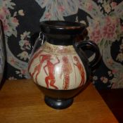 A 1970`s earthenware twin handled vase decorated with classical figural scenes on a black ground