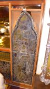 A C19th arched stained leaded glass panel with image of saint