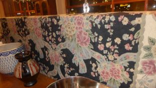 A William Morris style needlepoint tapestry the cream field decorated with flowers in a black border