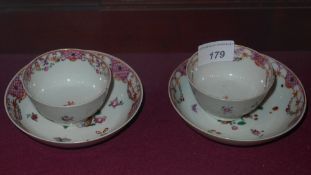 A Chinese famille vert pair of tea bowls and matching saucers decorated with flowers and
