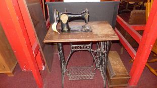 A Singer sewing machine on a cast iron base together with two iron shoemakers tools, and similar
