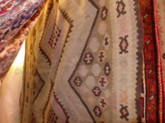 A Persian hand knotted Kelim rug having three central diamond medallion on a beige field within