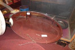An early C20th oval mirror with bevelled plate and flower etched detail