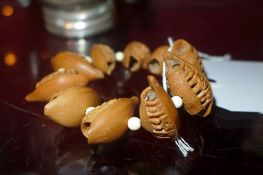 A Chinese carved nut bracelet in the form of figures in boats
