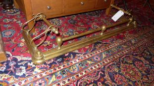 A Victorian brass fender with scrolling decoration