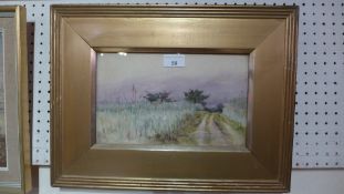 An early C20th Continental landscape study looking up a country path at dusk glazed and in gilt
