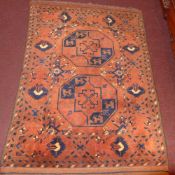 A Persian hand knotted prayer rug the terracotta field with repeating geometric motifs