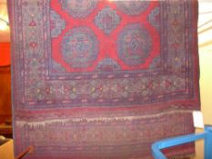 A fine hand knotted Afghan rug the rouge field with central pendant motifs within a multi border