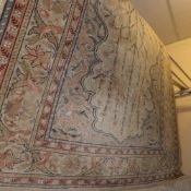 A fine hand knotted Persian rug the beige field decorated with flowers and birds in a multi border