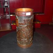 An Oriental carved hardwood brush pot having warriors in relief
