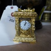 An ornate gilded miniature clock