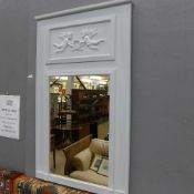 A distressed wall hanging mirror with cherub decoration